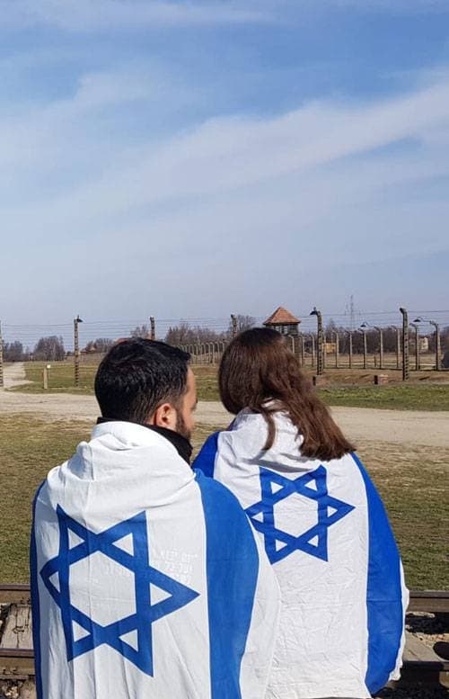 זוג עטוף בדגלי ישראל באושוויץ